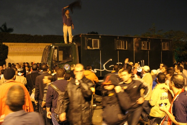 Demonstranter som erövrat ett polisfordon och målat "Under revolutionär kontroll" på.